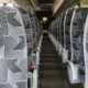 The interior of a charter bus, including many bus seats.