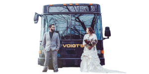 Couple in wedding attire standing in front of a Voigt bus