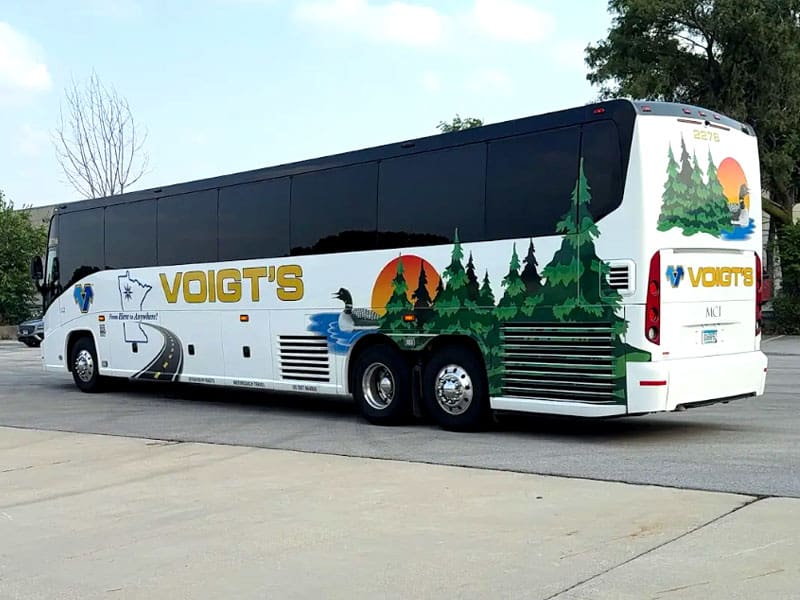 A Voigt’s charter bus is parked on the street.