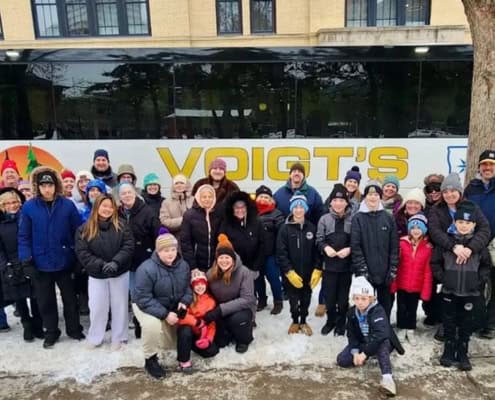 A tour group standing in front of a coach bus.