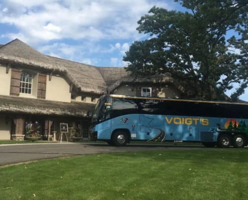 A shuttle bus parked in front of an event center.