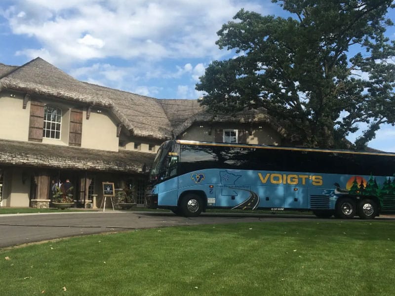 A shuttle bus parked in front of an event center.