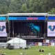 A musical festival stage featuring sponsor advertisements for Voigt’s Bus Service.
