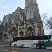 A Voigt’s coach bus parked in front of a historic church.